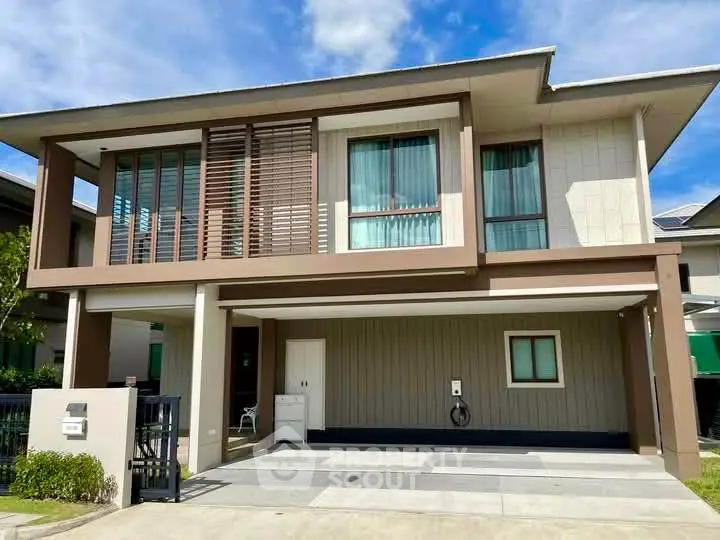 Modern two-story house with spacious driveway and contemporary design.