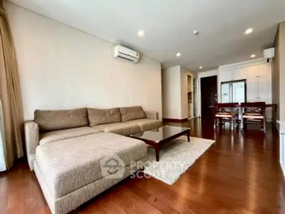 Spacious living room with modern furniture and wooden flooring in a stylish apartment.