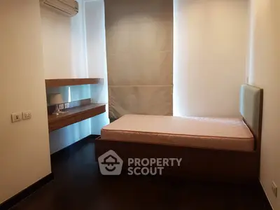 Cozy bedroom with single bed and modern wooden desk, perfect for minimalist living.