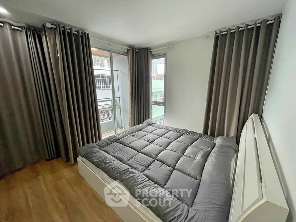 Modern bedroom with large windows and stylish curtains in a cozy apartment.