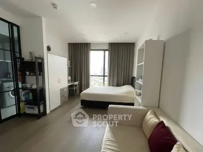 Modern studio apartment with cozy living area and large window view