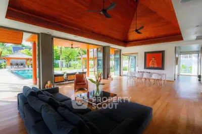 Luxurious open-plan living room with pool view and elegant wooden ceiling