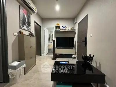Modern living room with sleek furniture and stylish decor, featuring a wall-mounted TV and air conditioning.