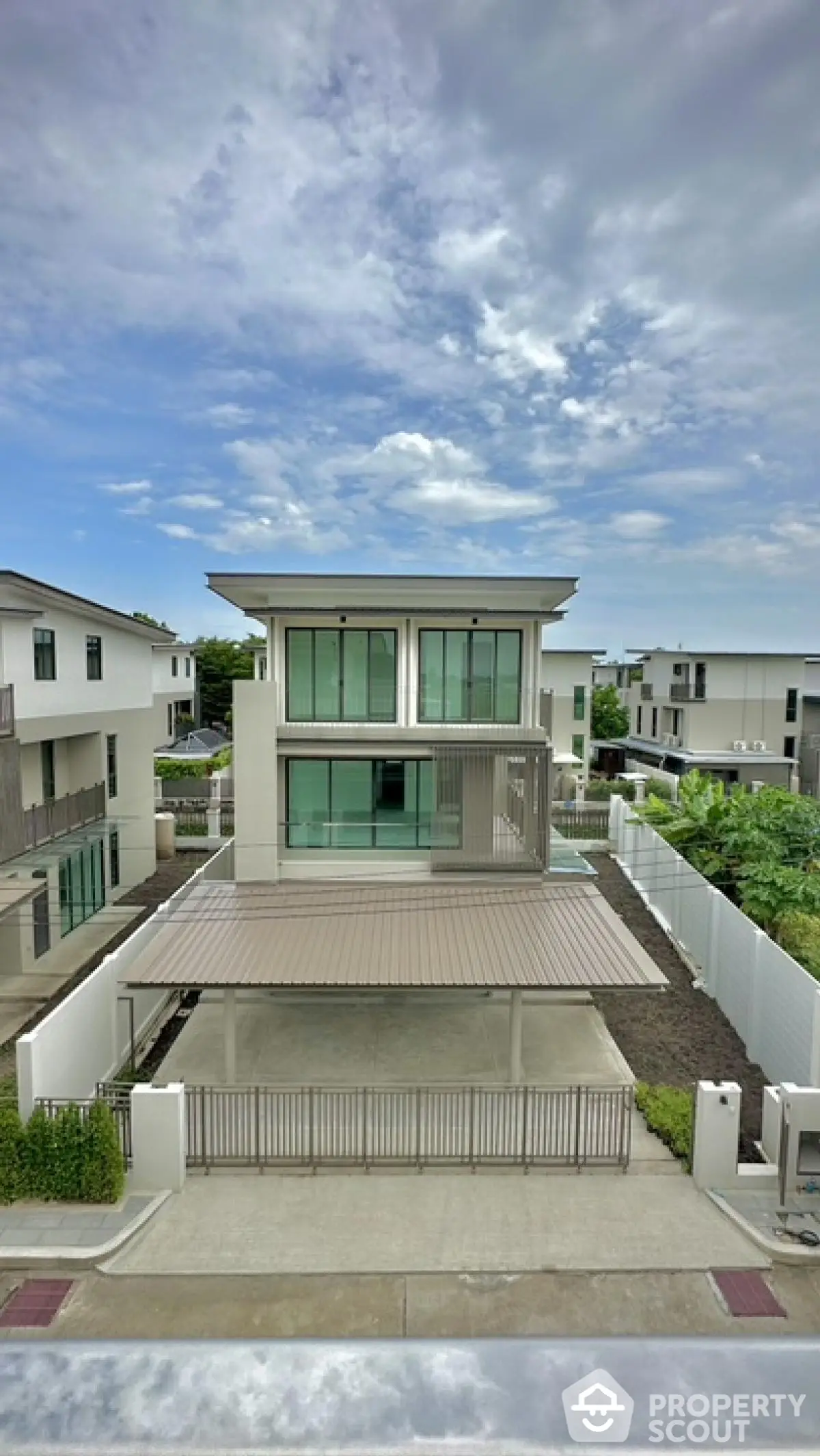 Modern two-story house with spacious driveway and contemporary design in a serene neighborhood.