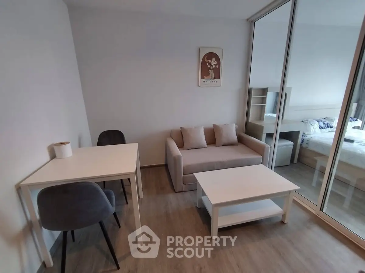 Modern living room with cozy sofa, dining table, and mirrored wardrobe in a stylish apartment.