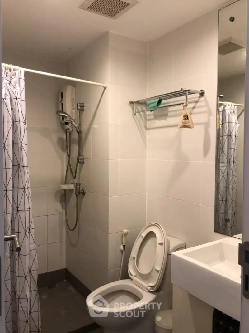 Compact bathroom with shower and modern fixtures in a cozy apartment.