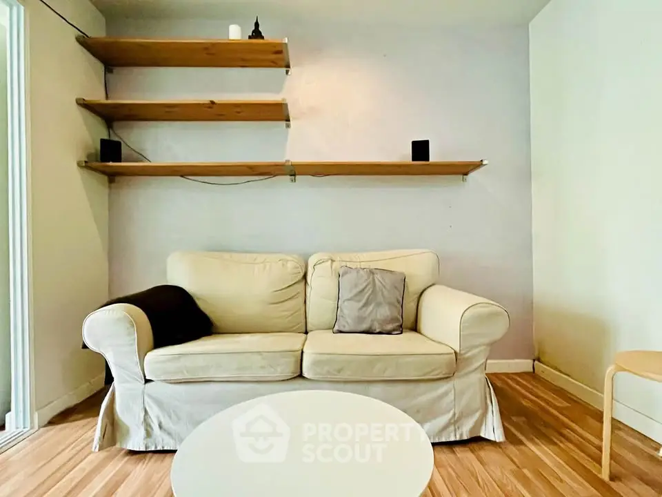 Cozy living room with beige sofa and wooden shelves, perfect for relaxation.