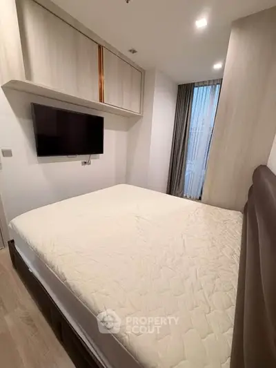 Modern bedroom with wall-mounted TV and stylish storage cabinets