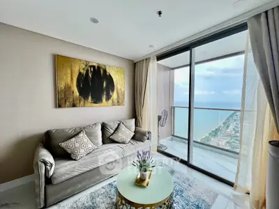 Luxurious living room with stunning ocean view from high-rise balcony, elegant decor and modern furnishings.