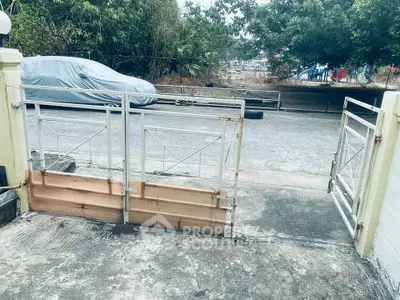 Secure gated entrance with driveway in a residential area, ideal for privacy and safety.