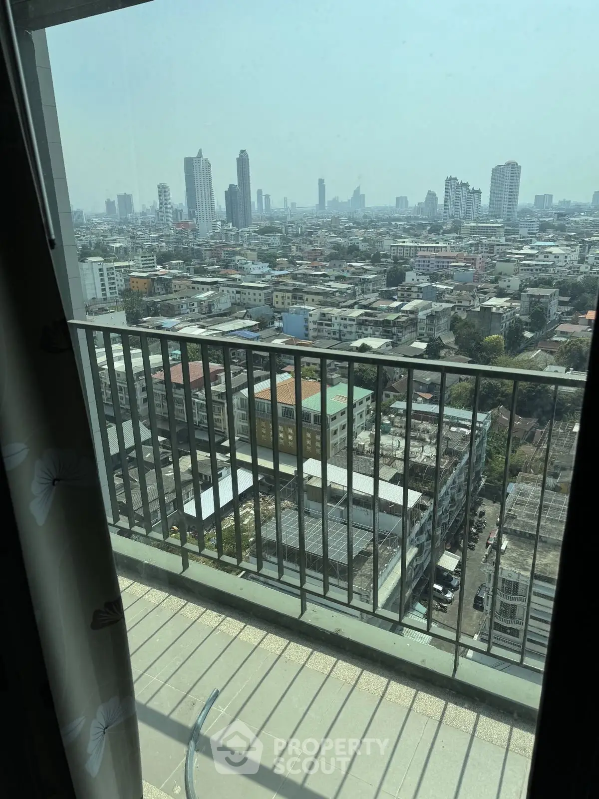 Stunning cityscape view from a high-rise balcony, showcasing urban skyline and vibrant city life.