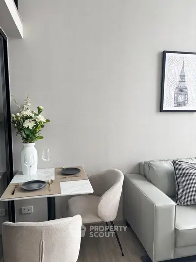 Modern living room with elegant decor, featuring a cozy dining area and stylish seating.