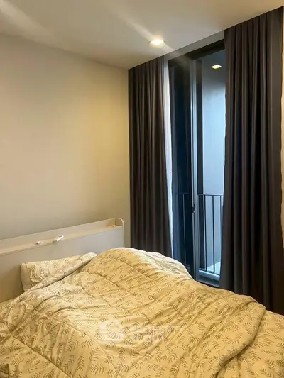 Cozy bedroom with modern decor and floor-to-ceiling window for natural light.