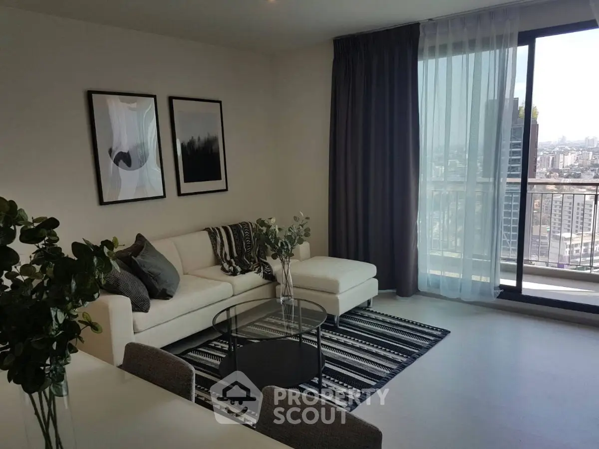 Modern living room with city view, stylish decor, and large windows for natural light.