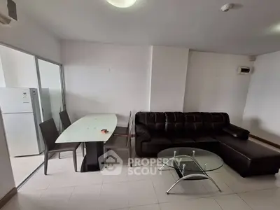 Modern living room with sleek furniture and dining area in open layout apartment.