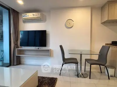 Modern living room with wall-mounted TV and glass dining table