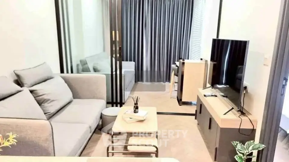 Modern living room with sleek furniture and large TV, perfect for relaxation and entertainment.