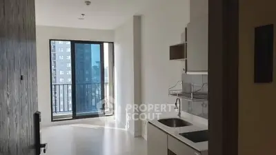 Modern apartment with sleek kitchen and balcony view in urban setting.