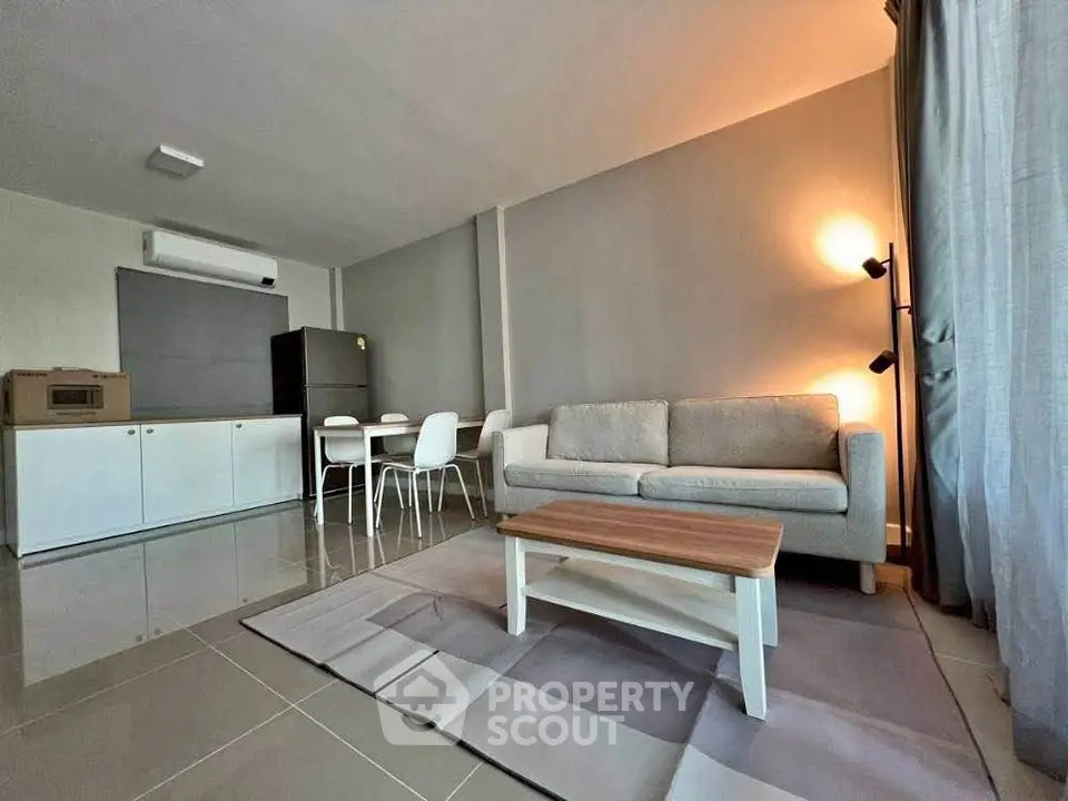 Modern living room with sleek furniture and open kitchen layout, perfect for urban living.