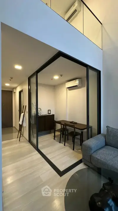 Modern living room with glass-enclosed study area and sleek furniture