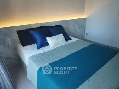 Modern bedroom with stylish lighting and cozy bedding in a contemporary home.