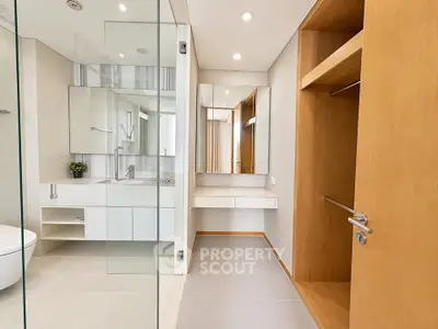 Modern bathroom with sleek design, glass shower, and wooden storage unit.
