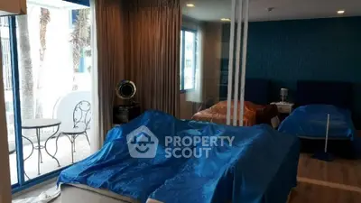 Spacious bedroom with large windows and elegant decor, featuring a cozy seating area.