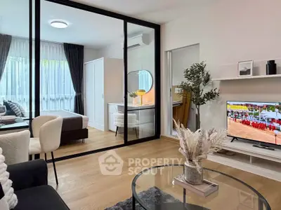 Modern living room with glass partition, stylish decor, and natural light