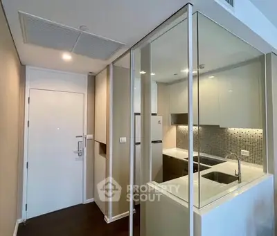 Modern compact kitchen with sleek cabinetry and stylish backsplash in a contemporary apartment.
