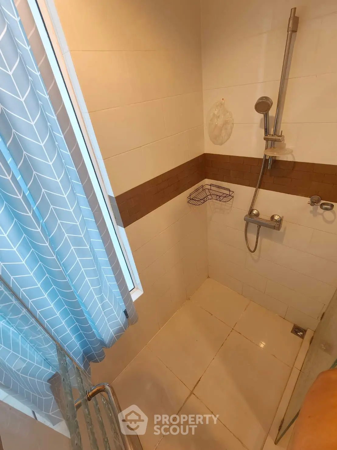 Modern bathroom with shower and stylish blue curtain in a cozy apartment.