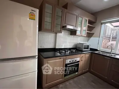 Modern kitchen with gas stove, oven, and spacious fridge in a stylish home.