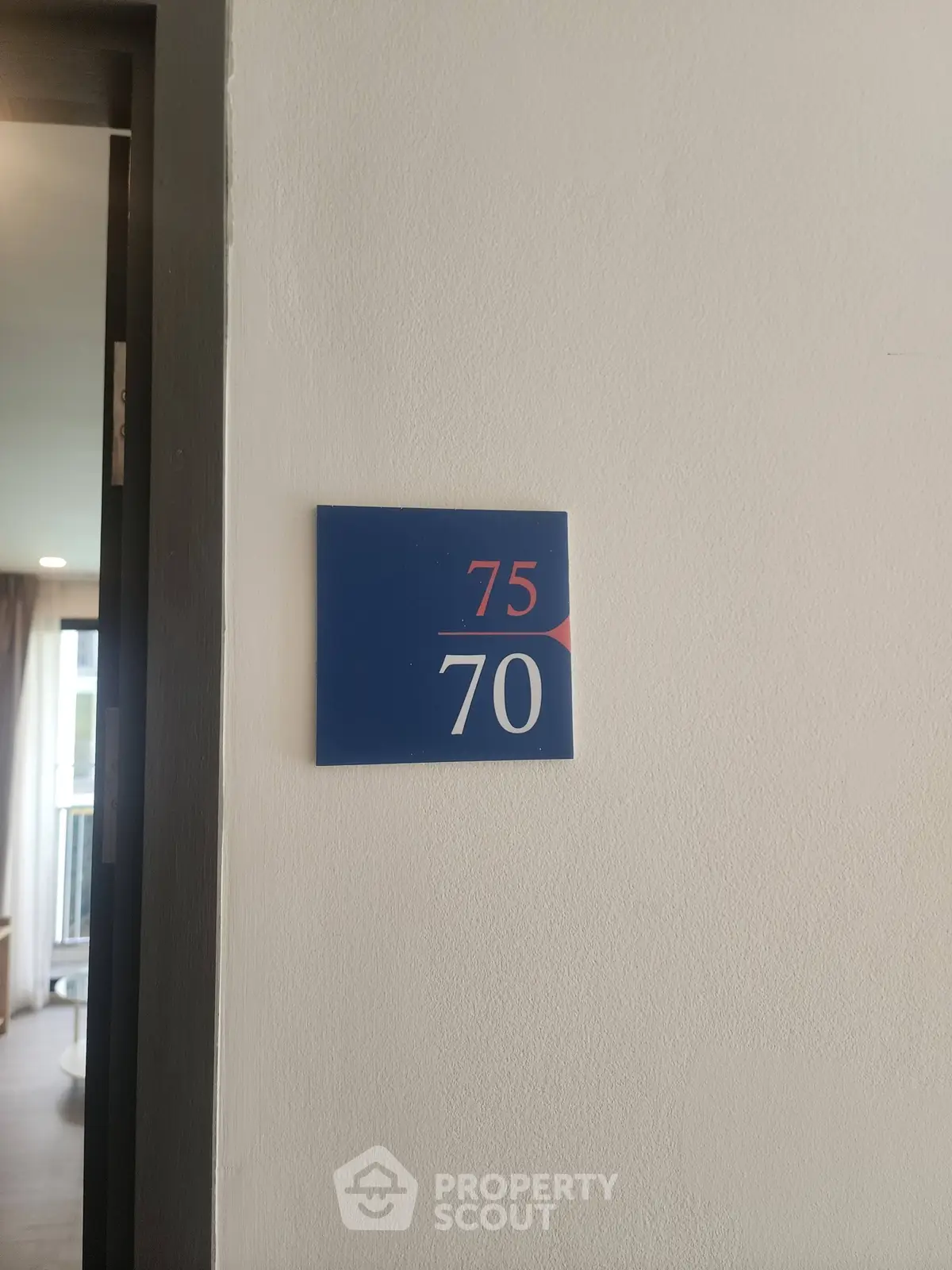Modern apartment entrance with room number signage, showcasing sleek design and inviting interior glimpse.