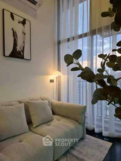 Stylish living room with cozy sofa and modern decor, featuring floor-to-ceiling windows and elegant lighting.