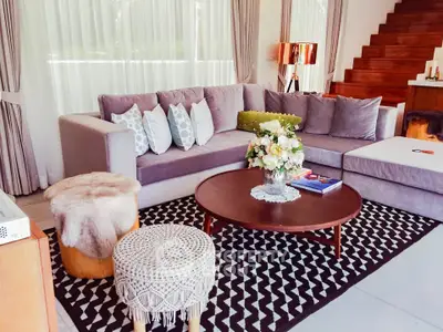 Stylish modern living room with plush sofa, chic decor, and elegant staircase