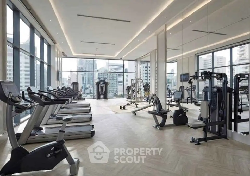 Luxurious high-rise gym with panoramic city views and state-of-the-art fitness equipment.