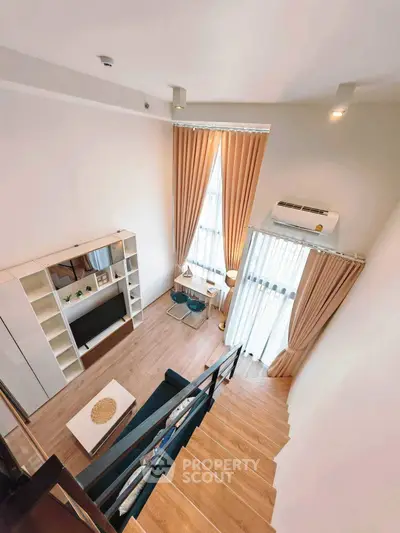 Modern loft-style living room with high ceilings and large windows