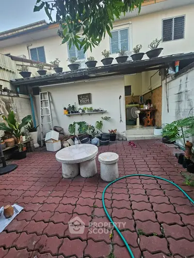 Charming backyard with patio seating and lush greenery, perfect for outdoor relaxation and entertaining.