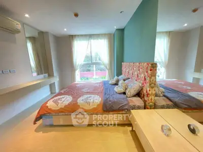 Spacious bedroom with large windows and stylish decor in modern apartment.