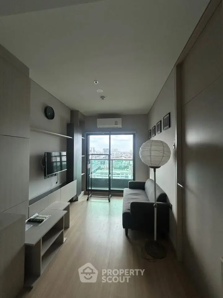 Modern living room with balcony view, sleek furniture, and stylish decor in a high-rise apartment.