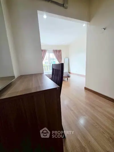 Spacious living area with wooden flooring and natural light, perfect for modern living.