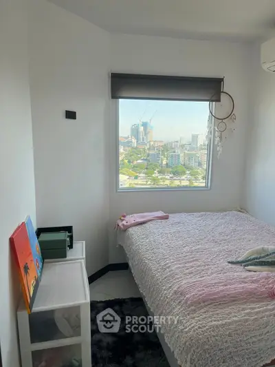 Cozy bedroom with city view, featuring a bed, dreamcatcher, and modern decor.