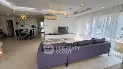Spacious modern living room with elegant decor and large windows offering city views.