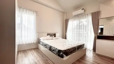 Modern bedroom with large windows and air conditioning in a stylish apartment.