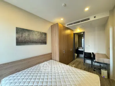 Modern bedroom with wooden furniture and ensuite bathroom in a stylish apartment.