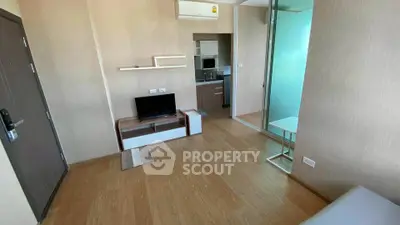 Modern living room with wooden flooring and compact kitchen area