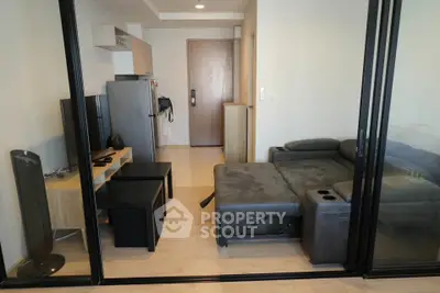 Modern living room with sleek furniture and glass partition in a stylish apartment.