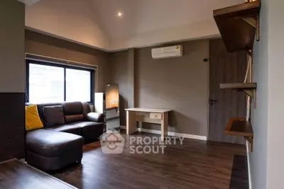 Spacious living room with modern decor and large window for natural light.