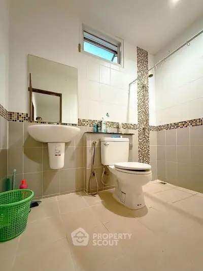 Spacious modern bathroom with elegant tile design and natural light.