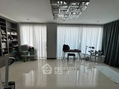Spacious living room with modern chandelier and floor-to-ceiling windows