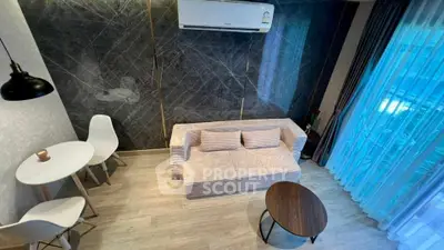 Modern living room with stylish furniture and large window view.